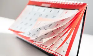 Strony kalendarza obracają się, symbolizując upływ czasu i zbliżające się zatwierdzenie sprawozdania finansowego.