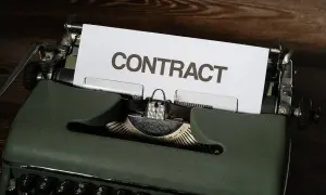 Stara maszyna do pisania z kartką z napisem "CONTRACT". Czas na wypowiedzenie umowy B2B.